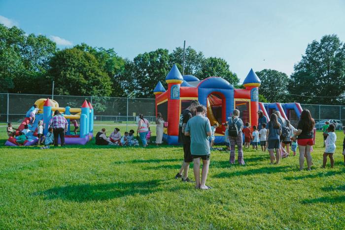 Bounce houses set up on a field for an outreach
