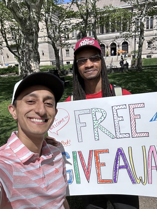 Josh holding a hand-lettered free giveaway sign