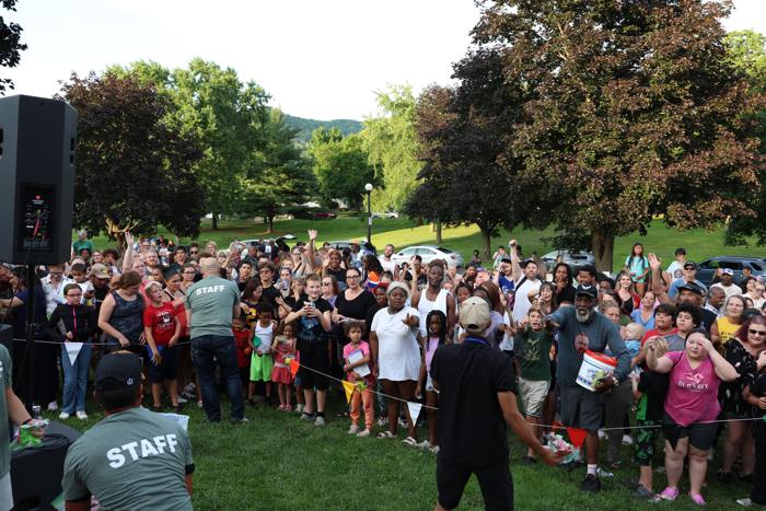 Families crowded in front of the sound system at a park outreach