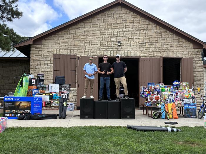 Team setting up sound and giveaways in front of a park building