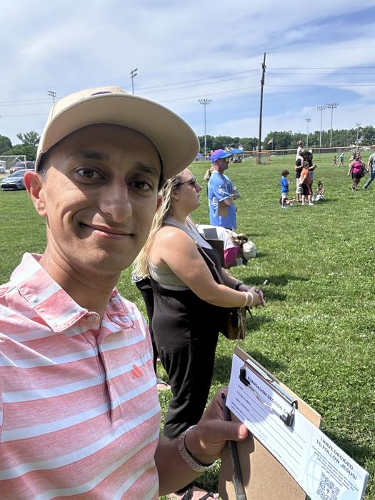 Josh with a clipboard at an outreach in a park