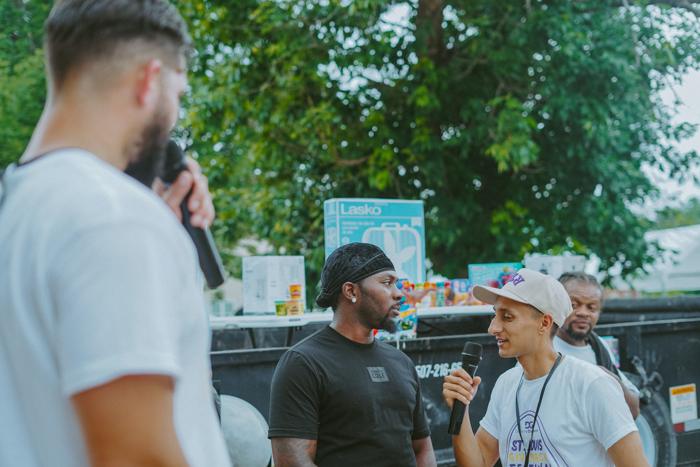 Praying with a man on the microphone at an outreach