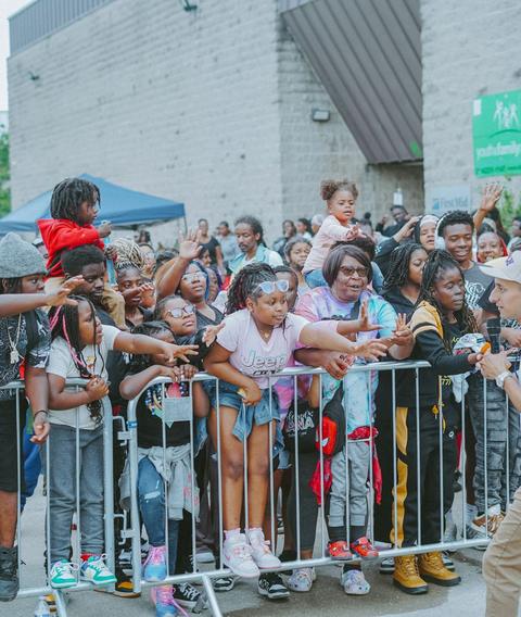 Families at the crowd barrier cheering during an outreach