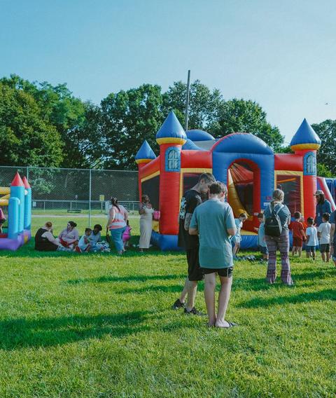 Bounce houses set up on a field for an outreach