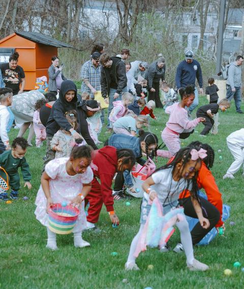 Kids running across a field at an egg hunt outreach