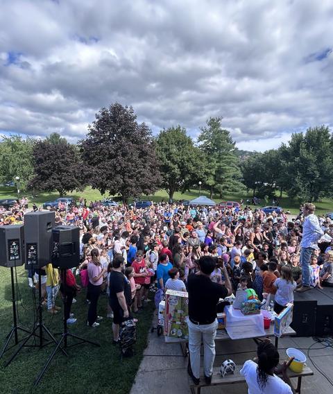 A large crowd on a field in front of the stage