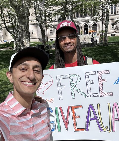 Josh holding a hand-lettered free giveaway sign