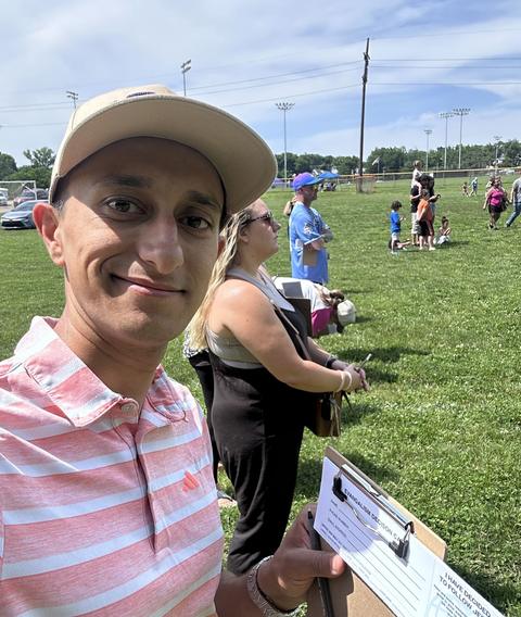 Josh with a clipboard at an outreach in a park