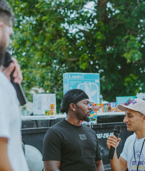 Praying with a man on the microphone at an outreach