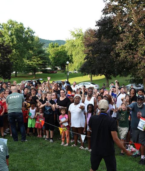 A crowd gathered around the stage in a park