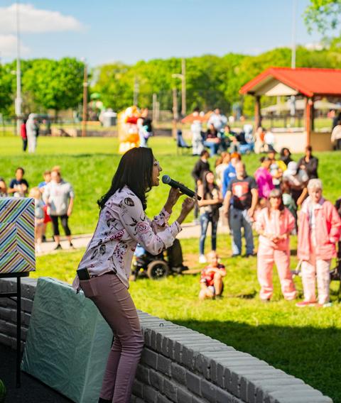 Kids dancing on the grass at a park outreach