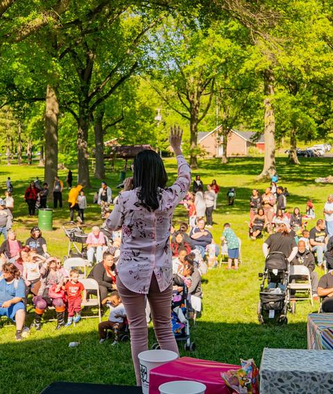 Families gathering in a park for an outreach